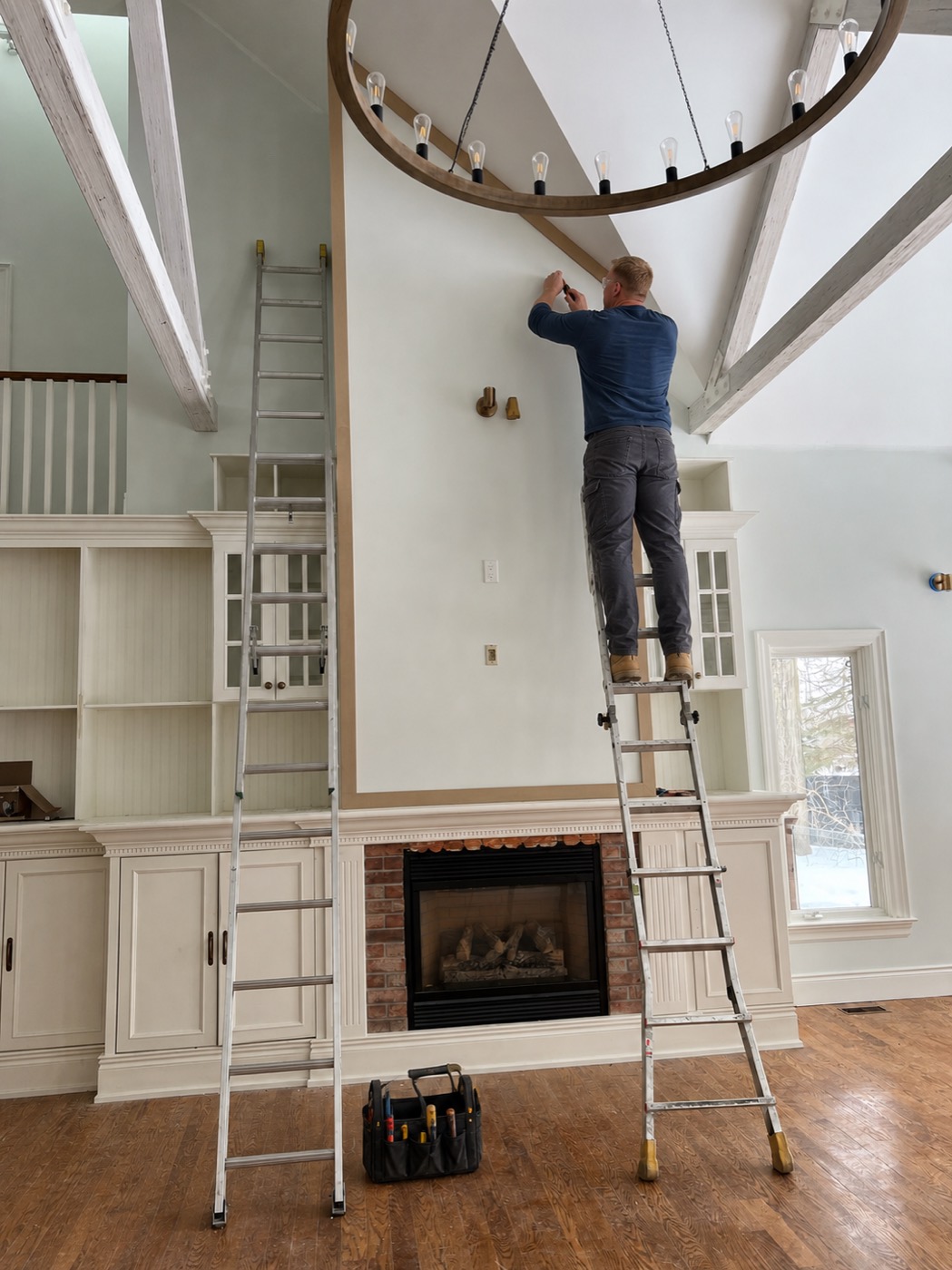 R2 WoodWork carpenter installing trim above a fireplace