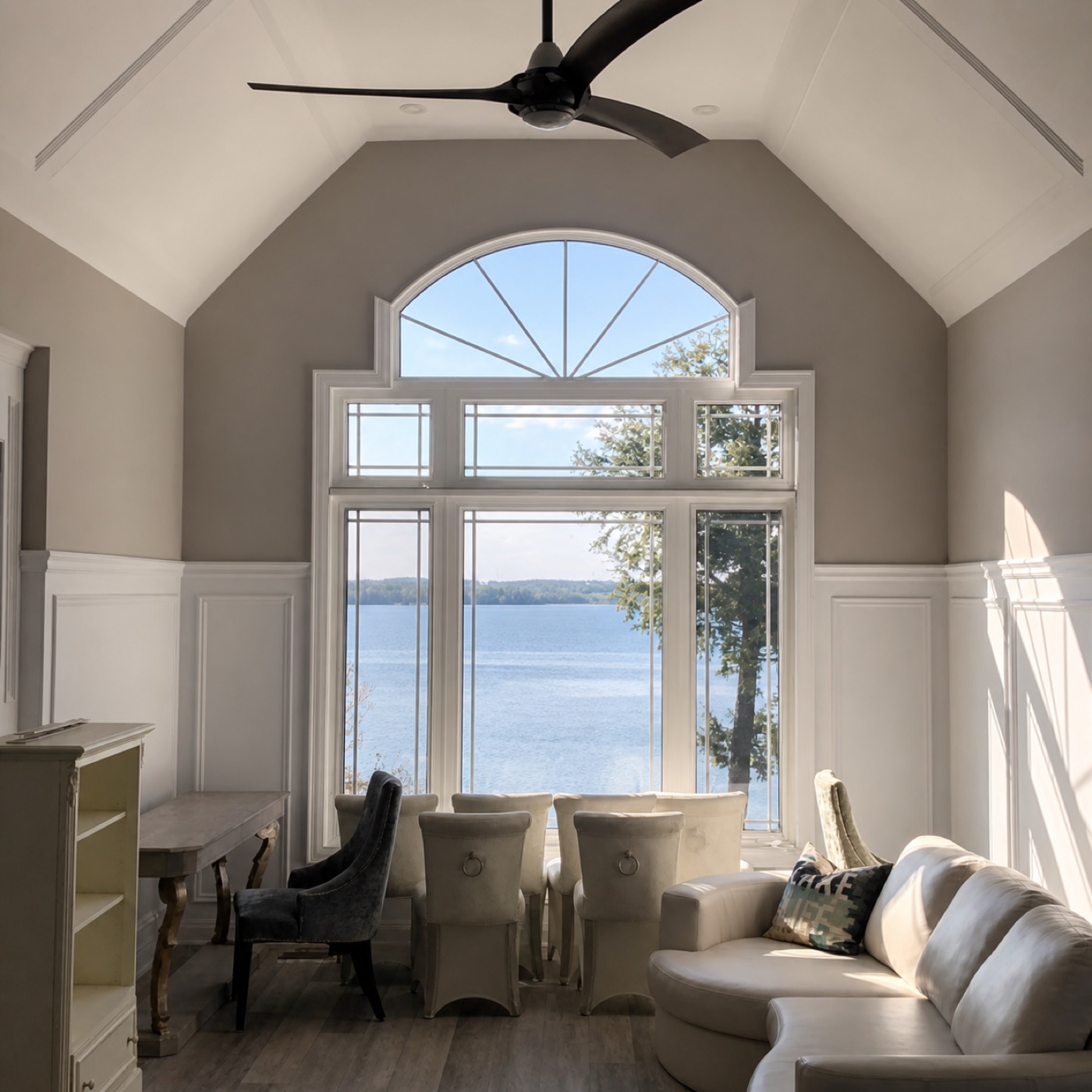 Vaulted living room with trim and lake-view windows