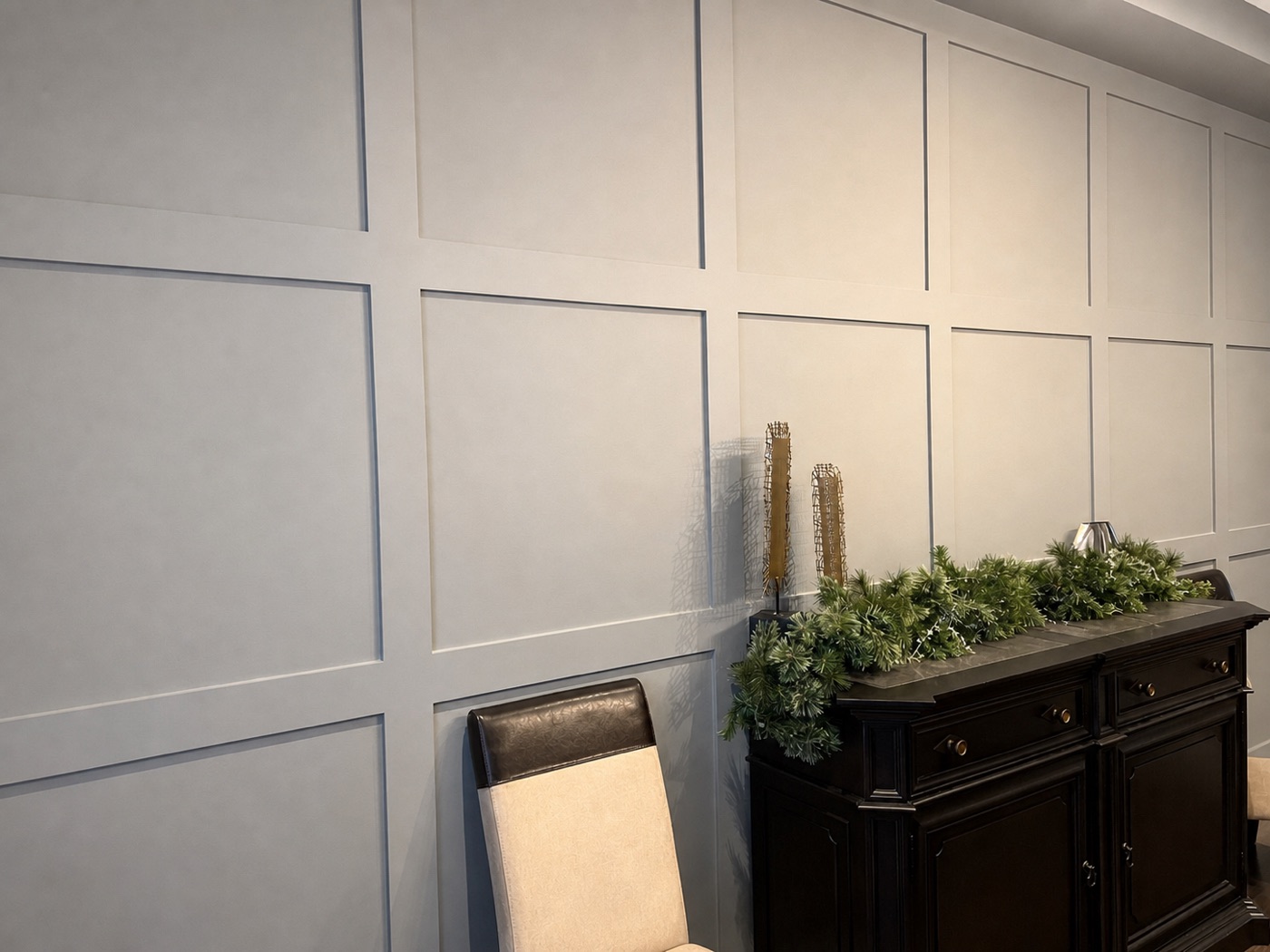 Grey grid wainscoting behind a dark sideboard